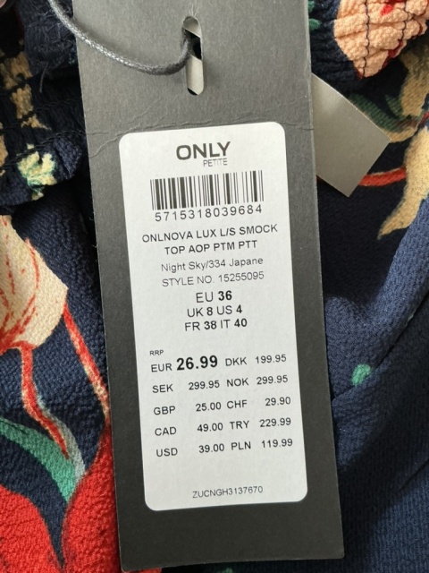 Zbliżenie na metkę Only i materiał granatowej bluzki damskiej