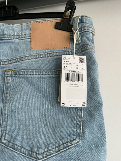 Zbliżenie na tylną część jasnych jeansów Mango Man i metkę spodni.